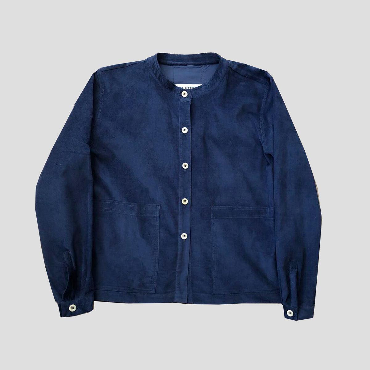 A navy blue corduroy jacket with a button-up front, buttoned cuffs, and two front patch pockets, displayed flat against a light gray background.