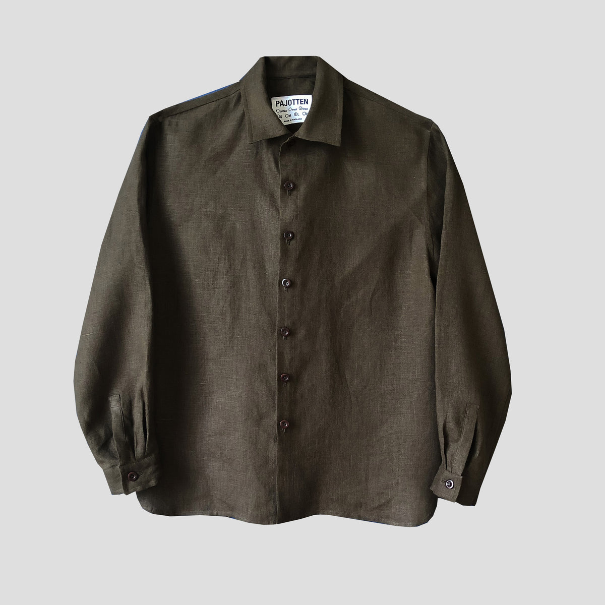 A dark olive green long-sleeve linen shirt by Pajotten featuring a button-down front and pointed collar, displayed against a neutral gray background.