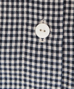 close up of button detail on a gingham cloth
