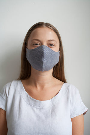 a girl wearing a checked cotton facemask made in the UK