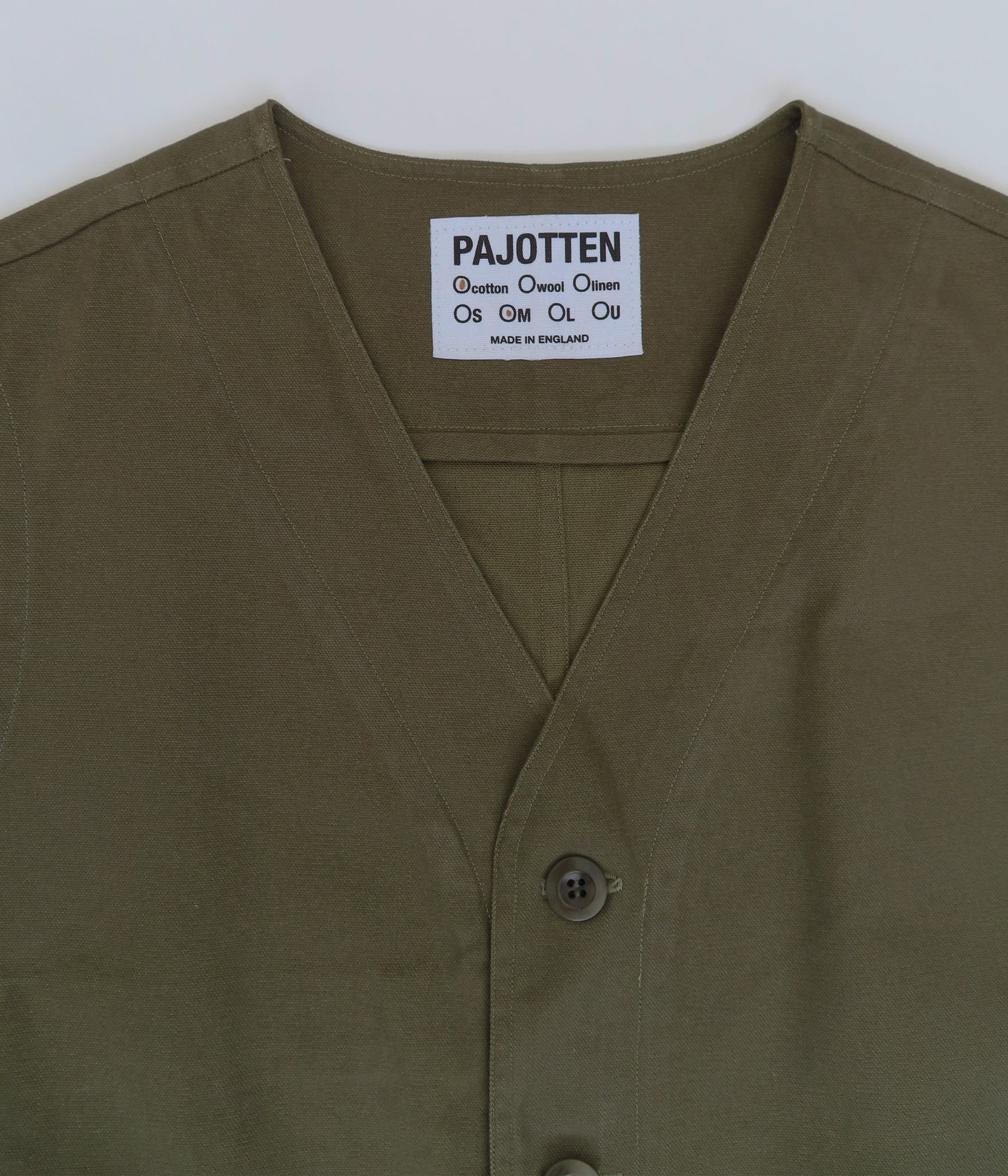 DETAIL OF THE GREEN COTTON WAISTCOAT SHOWING THE PAJOTTEN LABEL