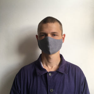 A man wearing a blue checked face mask made in the UK
