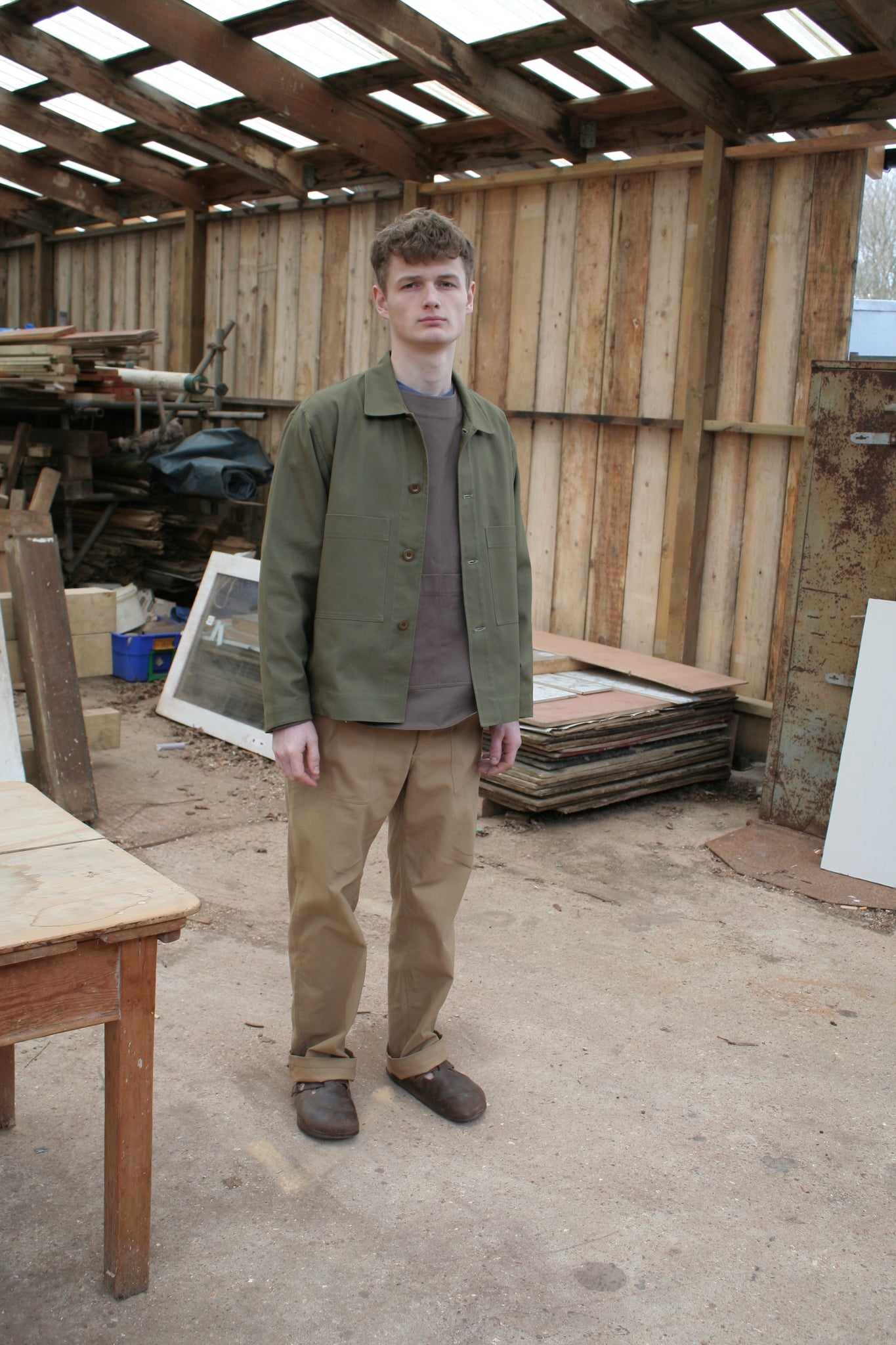sustainable British menswear sage cotton workwear jacket with brown artists top and tan cotton chore trousers