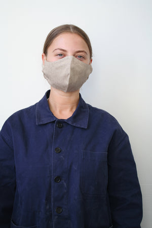 front view of a woman wearing a light brown face mask