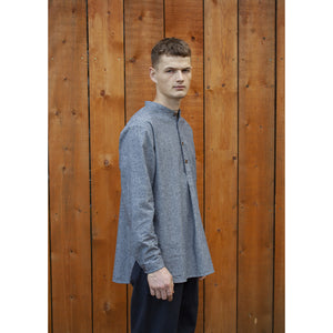 hemp and cotton shirt being worn by as young man standing in front of a wooden wall