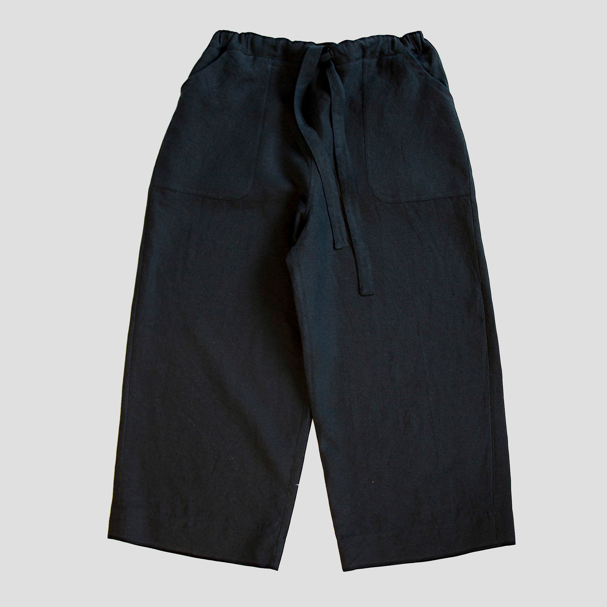 front view of a pair of dark navy heavy linen womenswear trousers with an elasticated waist and deep pockets